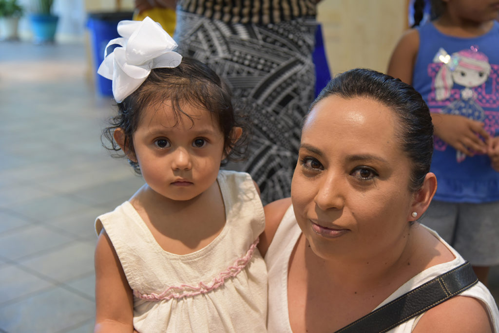 A mother and young daughter with a bow in her hair