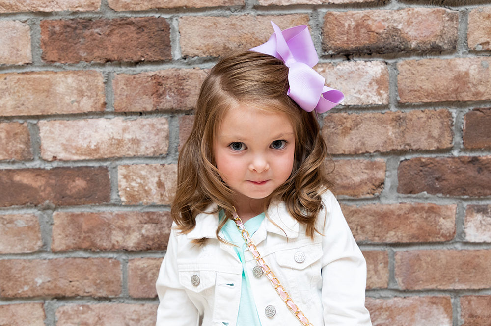 Cute small girl with a purple bow in her hair