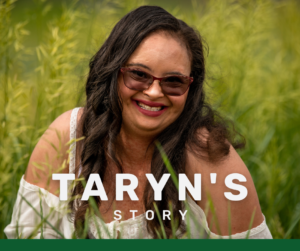 Woman in sunglasses smiling and sitting in a field of grass