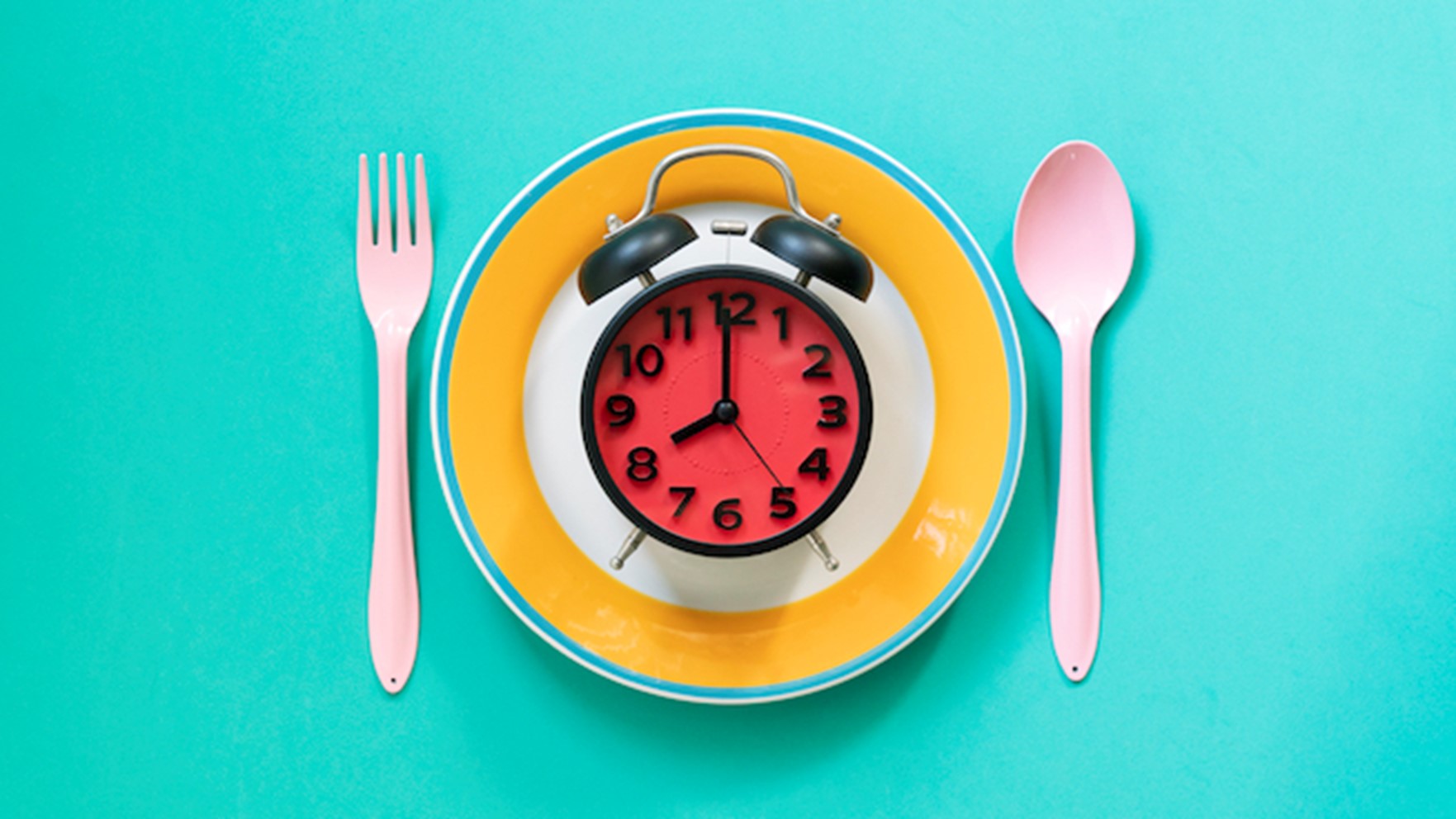 Fork and Spoon alongside Plate with clock on top