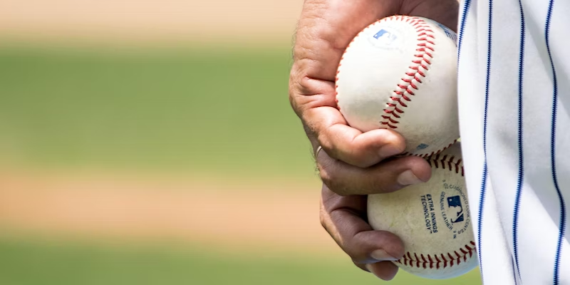 Baseball player holding 2 baseballs