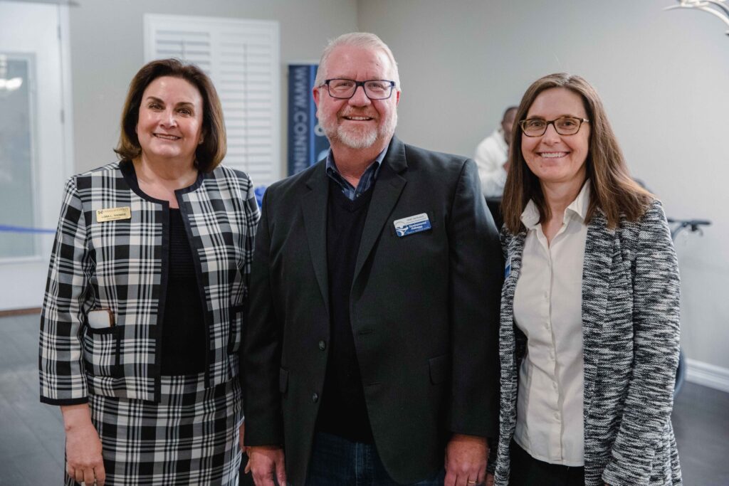 Pictured from left to right are Lora L. Thomas, Commissioner of Douglas County, Matt VanAuken, CEO & Executive Director of Developmental Pathways, and Alexa Lanpher, Executive Director of Continuum of Colorado. They are smiling at the camera and standing side by side.