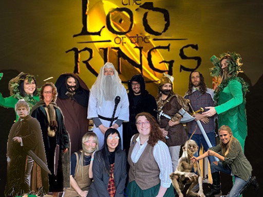 Large group of adults in front of a large gold ring and black font saying "LOD of the Rings." All are dressed as different characters including the hobbits, elves, dwarves, and wizards.