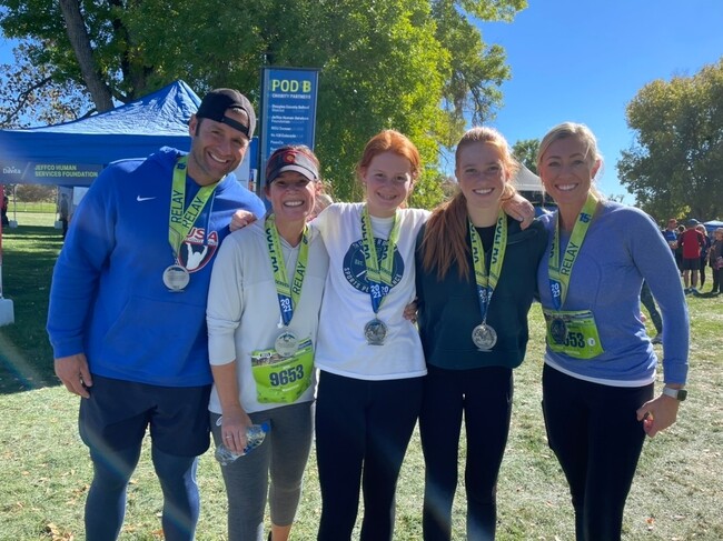 Group of four women and one male smiling wearing Colfax Marathon metals