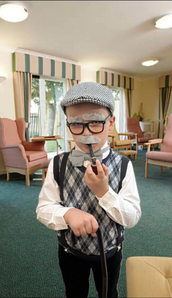 Young child dressed as elderly man smoking a pipe.