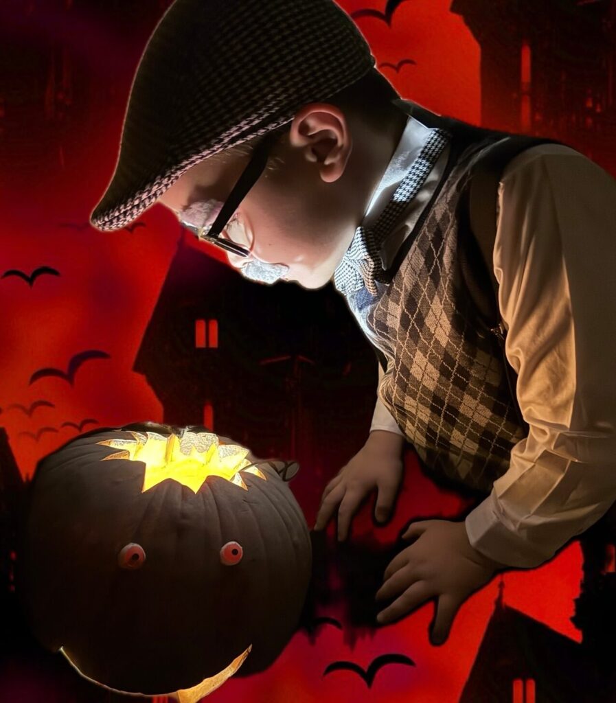 Small child touching black/glowing jack-o-lantern