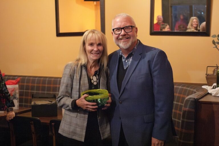 Woman in blond hair and man in a suit smiling