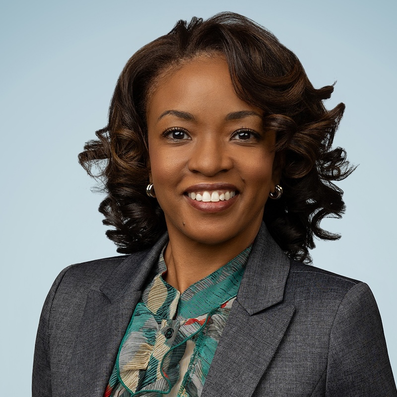 A woman in black shoulder length hair smiling
